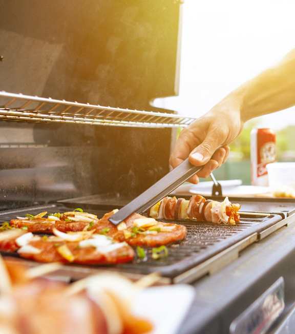 A person grilling food on a barbecue.