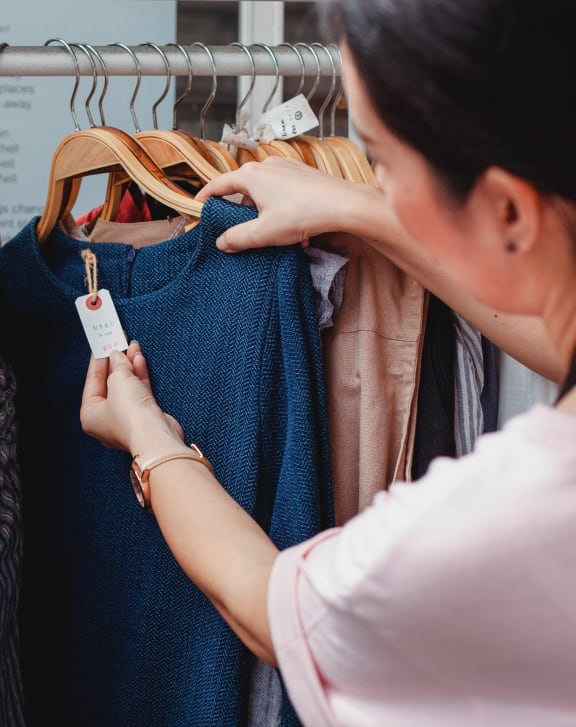 two women looking at clothes on a rack