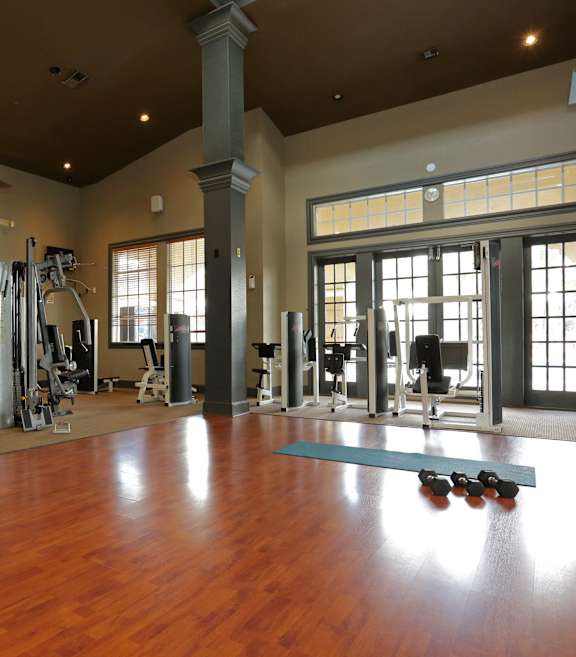 A gym with a variety of equipment including weights and machines.