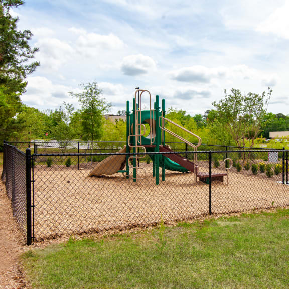 a playground with a swing set and slides in a park