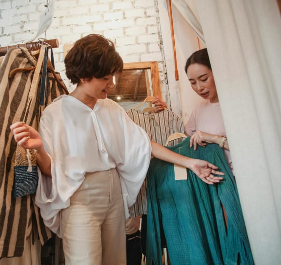 two women in a clothing store looking at clothes
