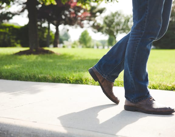 two people walking on the sidewalk in the park