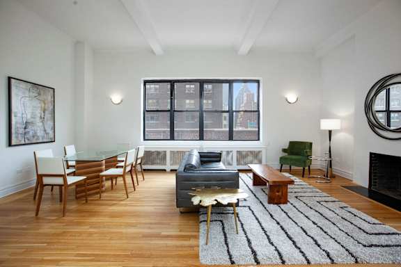 A living room with a fireplace and a couch.at Sutton Collection, New York, 10022