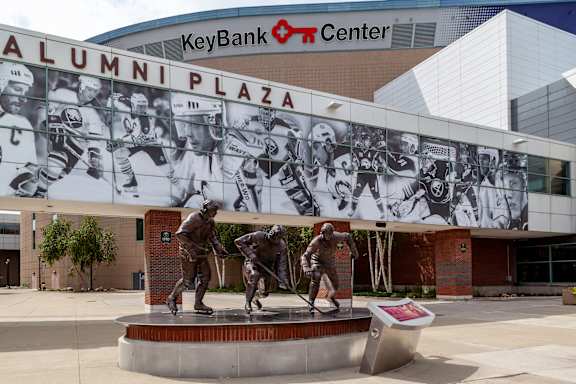 A statue of three hockey players is in front of the Key Bank Center at The Lofts at Elk Terminal Apartments, Buffalo,14204
