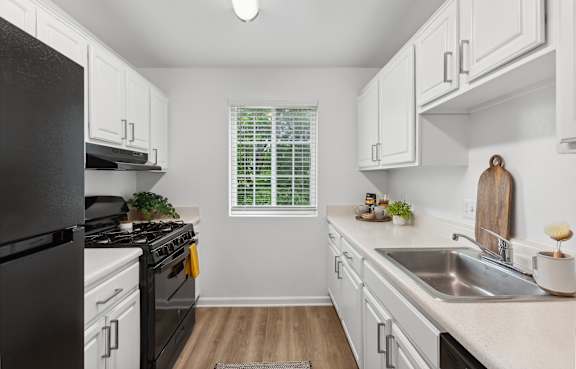 A kitchen with black and white appliances and cabinets.