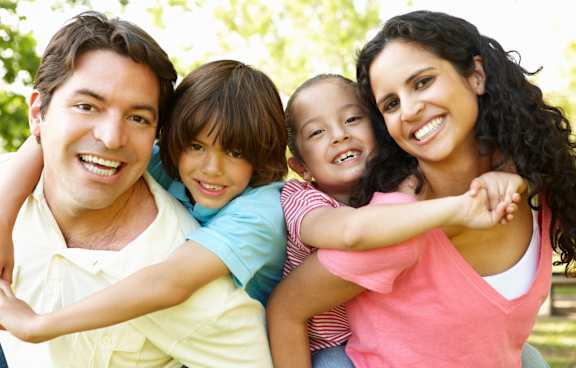  A young child is being held by an adult and another child.