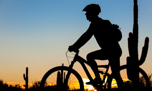 a man riding a bike in the desert
