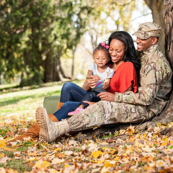 a soldier and his wife and daughter sitting under a tree at Gates of West Bay, Norfolk Virginia
