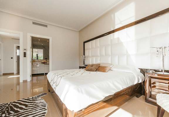 A bedroom with a large bed and a zebra rug on the floor.