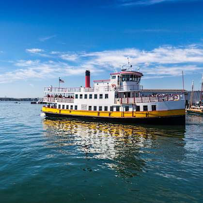 A yellow and white boat is floating on the water.
