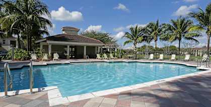 A pool with a house in the background.