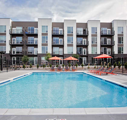 A large swimming pool in front of apartment buildings.