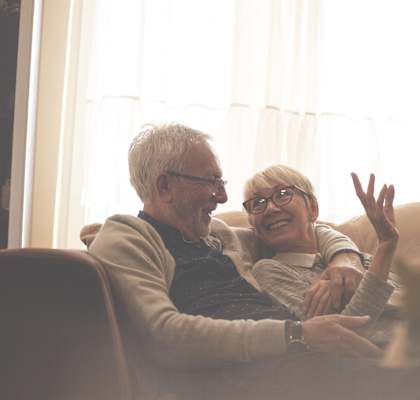 Elderly couple cuddling on the couch at ReNew Aurora, Illinois