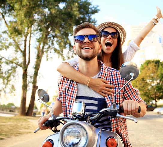 A man and woman are riding a motorcycle together.