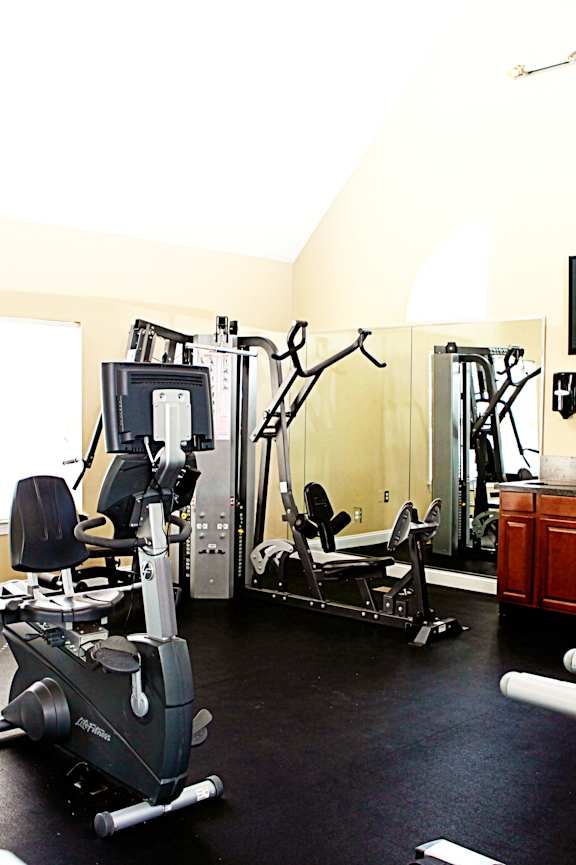 A gym with a variety of exercise equipment including treadmills, stationary bikes, and weight machines.at Summerland Heights, Woodbridge Virginia