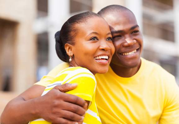 a man and woman in yellow shirts smile at the camera