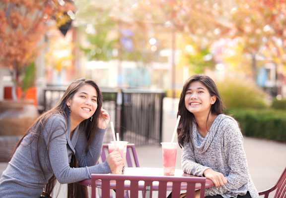 two girls sitting at a table with drinks in front of them  at Nineteen800, Cupertino