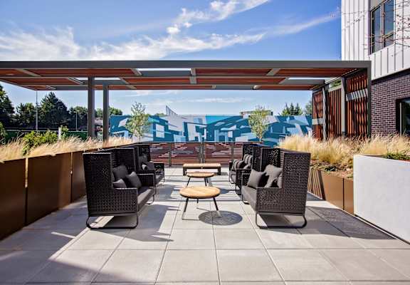 A patio with a table and chairs under a roof.