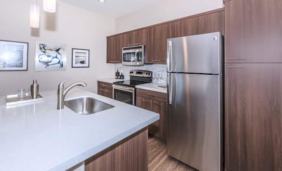a kitchen with white countertops and a stainless steel refrigerator at The Canyons at Linda Vista Trail, Oro Valley