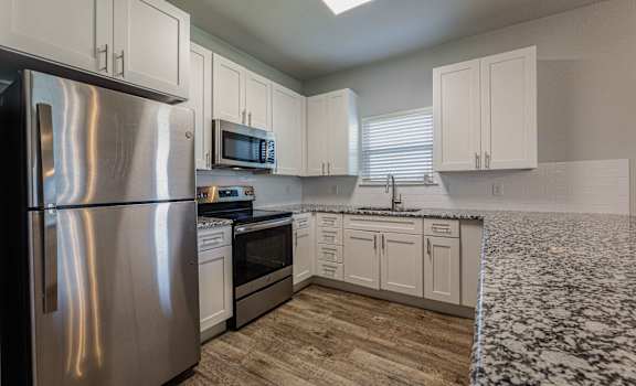 a kitchen with stainless steel appliances and white cabinets