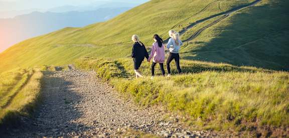 Three people are walking on a grassy hill.at OTAVON APARTMENTS, Novato, CA