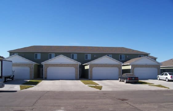 a house with three garages and a car parked in front of it
