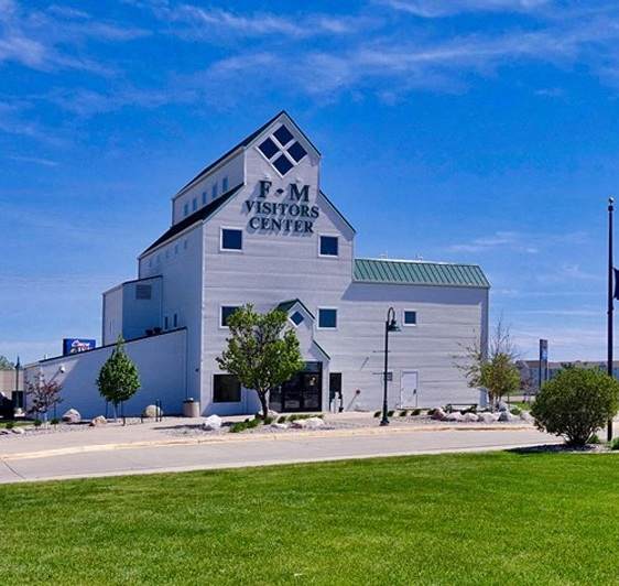 a white building with an flag in front of it and a blue sky