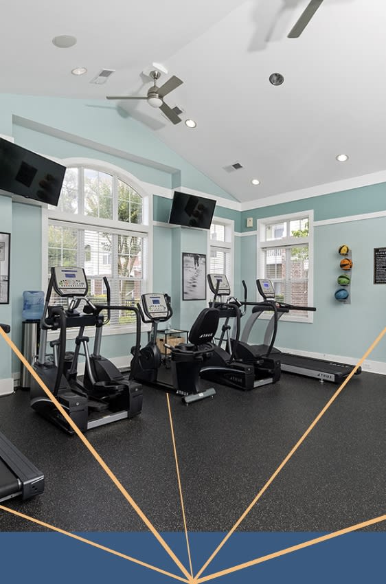 a gym with treadmills and other exercise equipment in a room with windows at Breakers Point, South Carolina, 29579