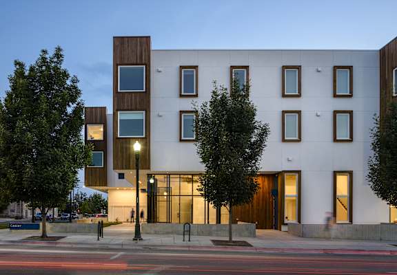 A modern building with a white facade and dark brown accents.