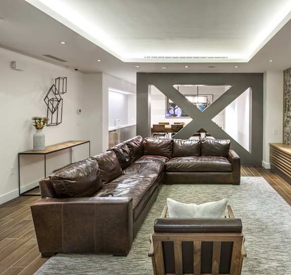 A modern living room with a brown leather couch and a stone wall.at 21 West, New York, 10006