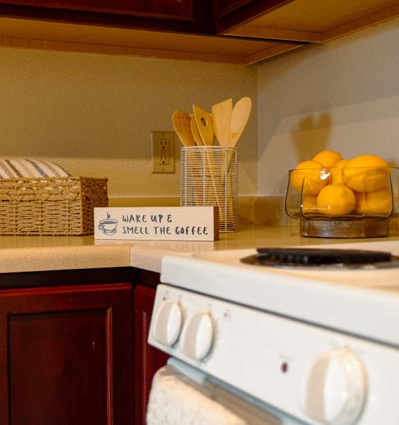 A kitchen with a white stove and a basket on the counter.