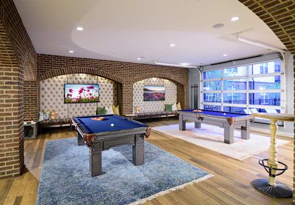A pool table in a room with brick walls.