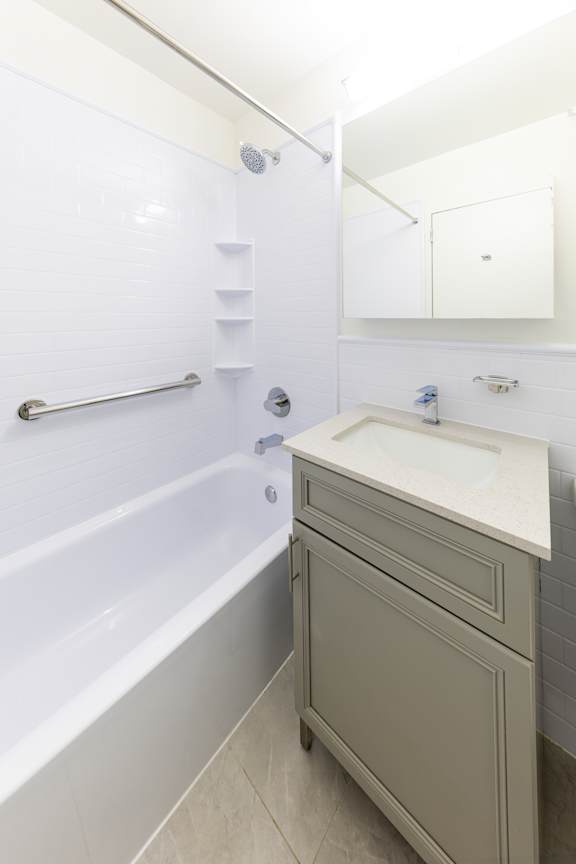 A white bathroom with a sink and a bathtub.