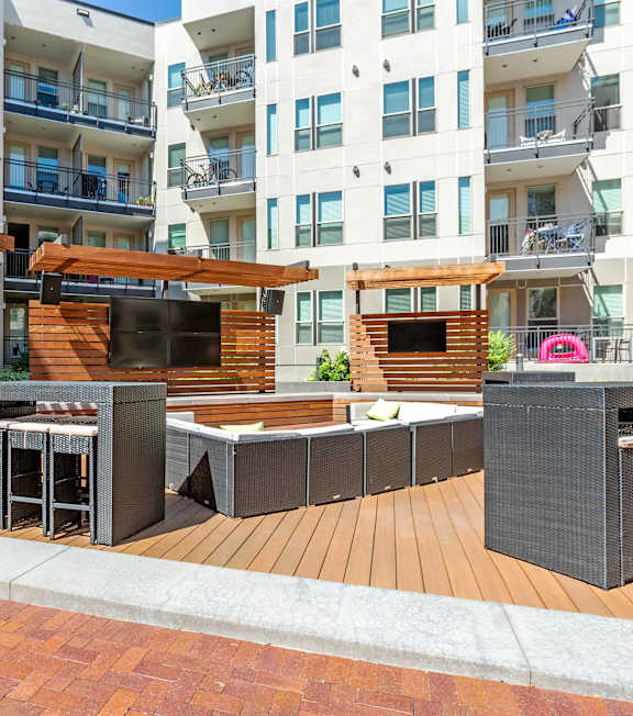 A modern outdoor seating area with a wooden deck and a television at Regatta Sloans Lake Apartments, Colorado, 80204