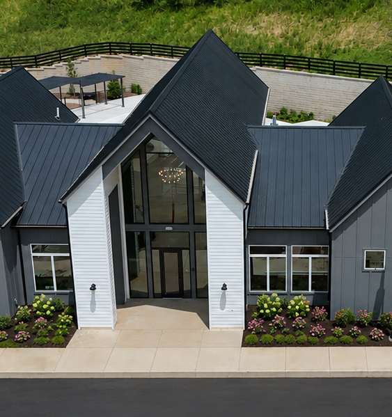 A modern house with a black and white exterior and a large glass window.