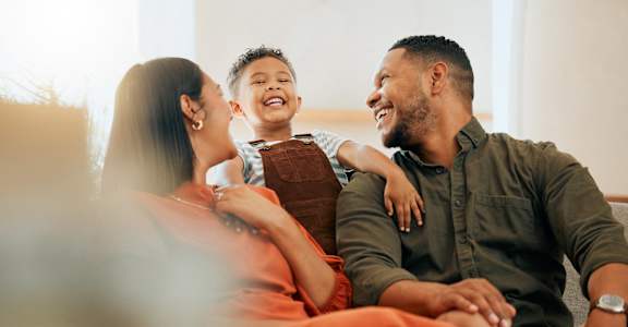 a man and woman sitting on a couch with a child