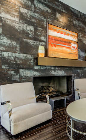 A living room with a fireplace and a painting above it.