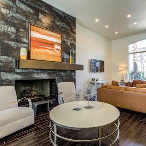 A living room with a fireplace and a painting above it.