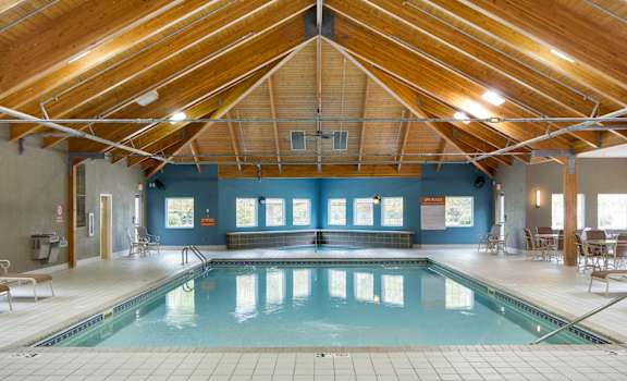 A large indoor swimming pool with a wooden ceiling.