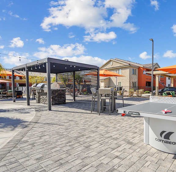 A sunny day at the outdoor seating area with green grass and trees.