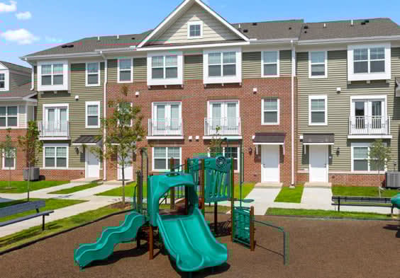 a playground with a slide in front of an apartment building