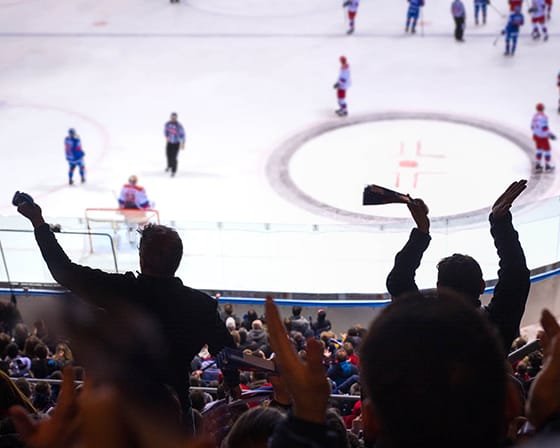 A hockey game is in progress with players on the ice and spectators in the stands.