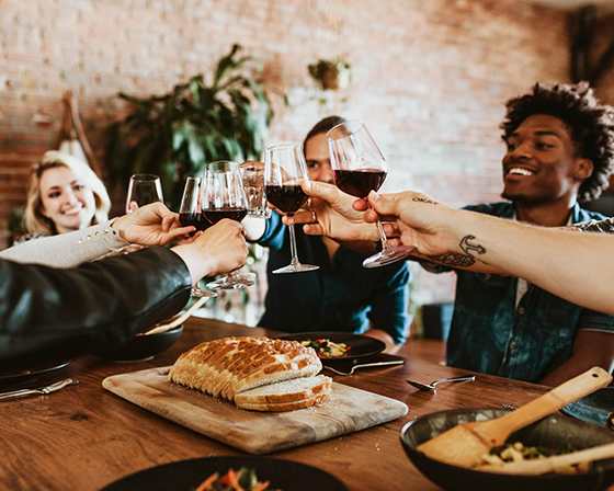A group of people toasting with wine glasses at a table.