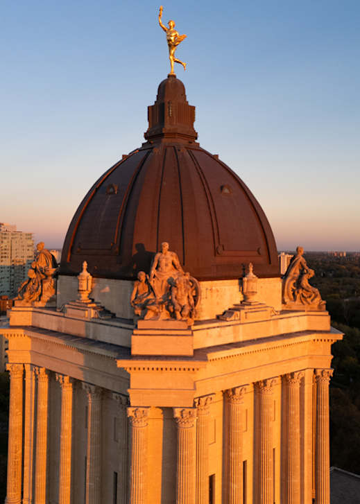 A building with a statue on top and columns.