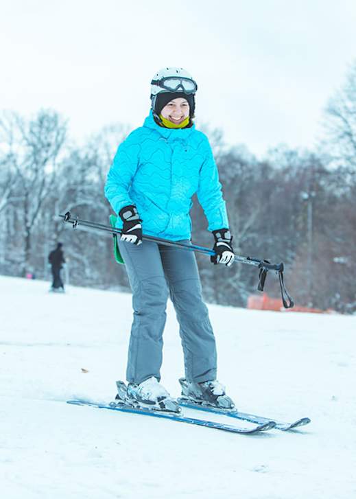 A person in a blue jacket is skiing on a snowy slope.