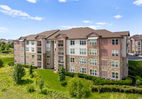 Apartment building with green yard in front of it at The Residences at Bluhawk Apartments, Kansas