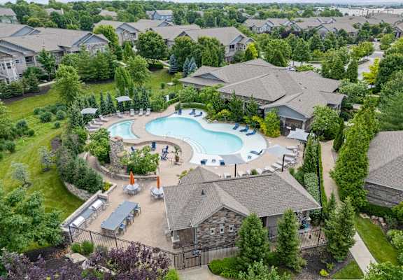 A large swimming pool surrounded by houses and trees.