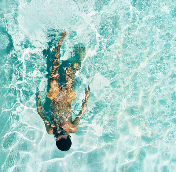a woman swimming in a pool with her feet in the water