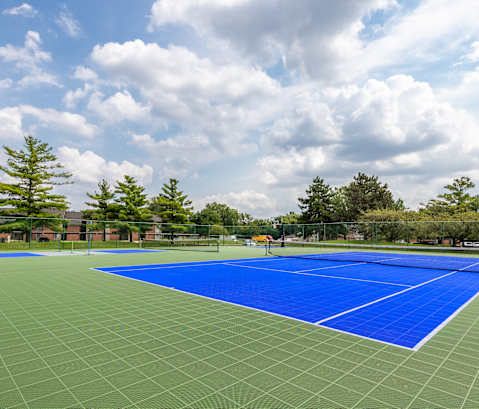 A tennis court with a blue surface and white lines.