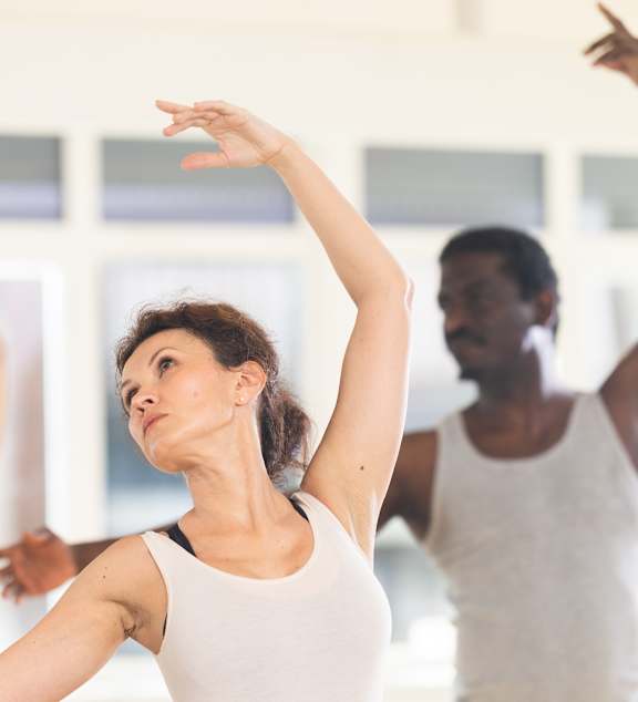 A group of people are practicing dance in a studio.